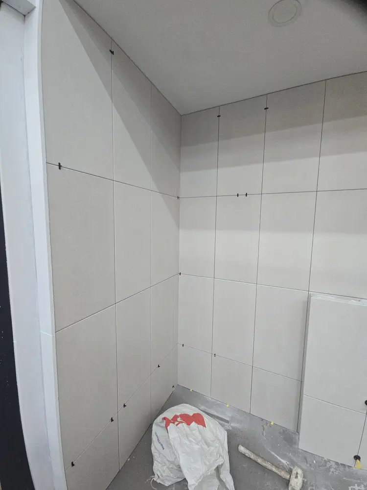 천장까지 이어지는 크림 톤 타일 마감